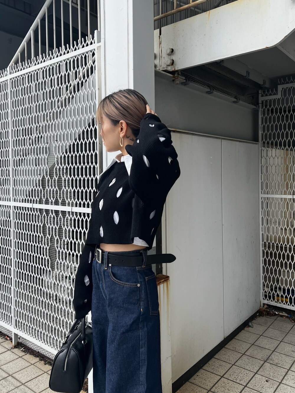 ブルー系のデニムパンツ、ホワイト系のローファー、ブラック系のニット/セーターを着用したレディースの冬コーディネートの5枚目の写真