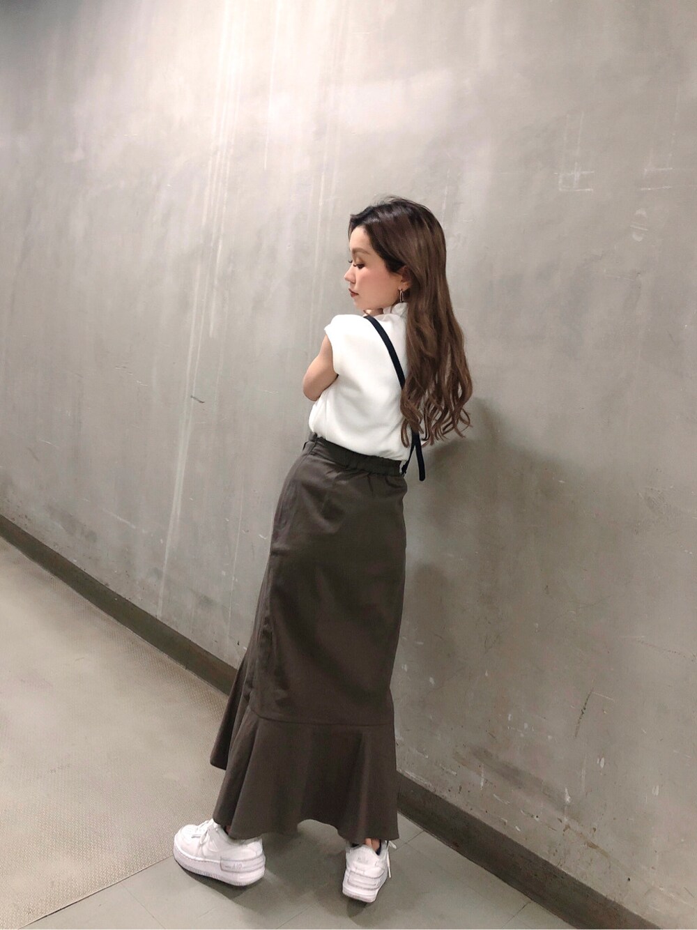 グレー系のスカート、ブラック系のハンドバッグ、ホワイト系のTシャツ/カットソーを着用したレディースの春コーディネートの2枚目の写真