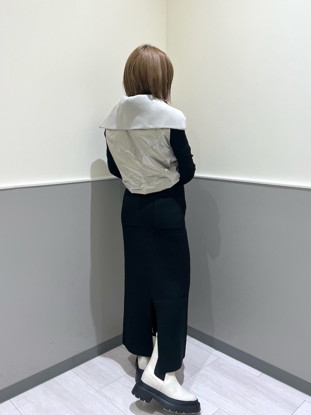 ホワイト系のブーツ、ブラック系のスカート、シルバー系のブルゾンを着用したレディースの冬コーディネートの3枚目の写真