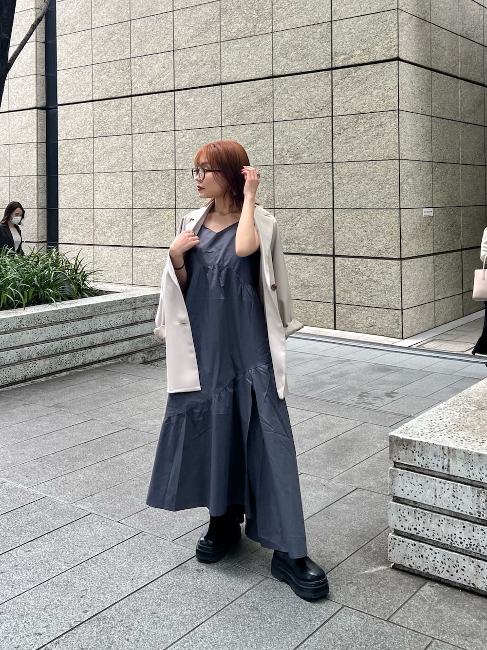 ベージュ系のテーラードジャケット、ブラウン系のニット/セーター、グレー系のワンピースを着用したレディースの春コーディネートの4枚目の写真