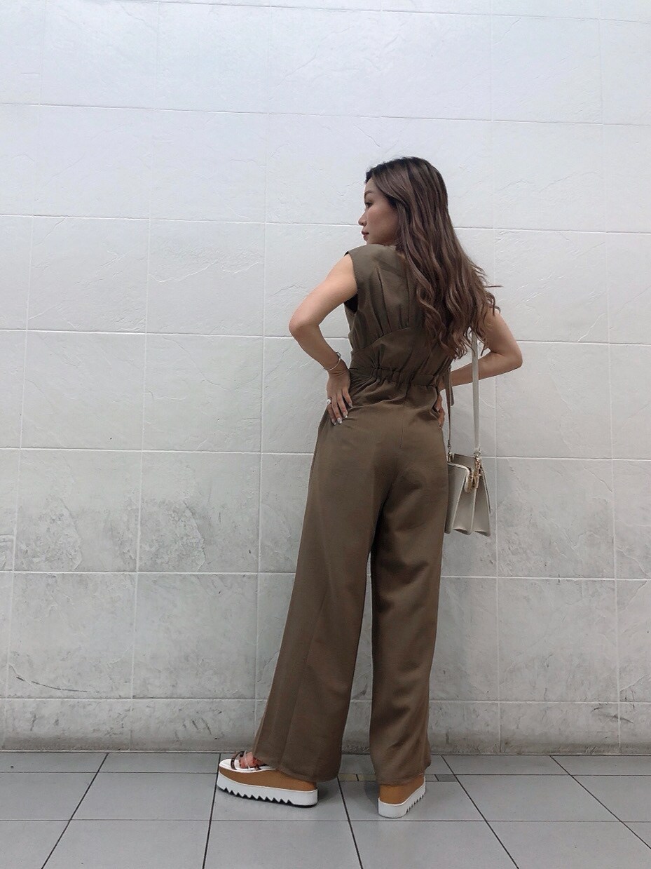 ホワイト系のサンダル、ホワイト系のハンドバッグ、ベージュ系のつなぎ/オールインワンを着用したレディースの夏コーディネートの2枚目の写真