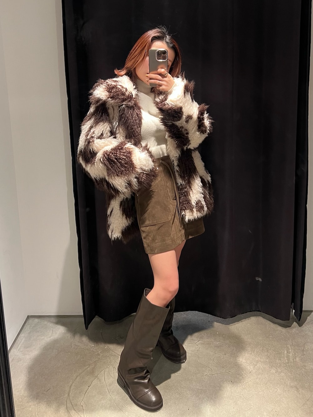 その他のブルゾン、ブラウン系のブーツ、ホワイト系のニット/セーターを着用したレディースの冬コーディネートの2枚目の写真