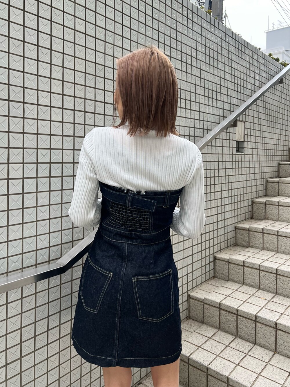 ホワイト系のニット/セーター、ブルー系のワンピース、ブラック系のブーツを着用したレディースの冬コーディネートの6枚目の写真