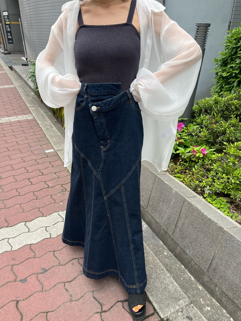 ホワイト系のシャツ/ブラウス、グレー系のニット/セーター、ブルー系のデニムスカートを着用したレディースの春コーディネートの6枚目の写真