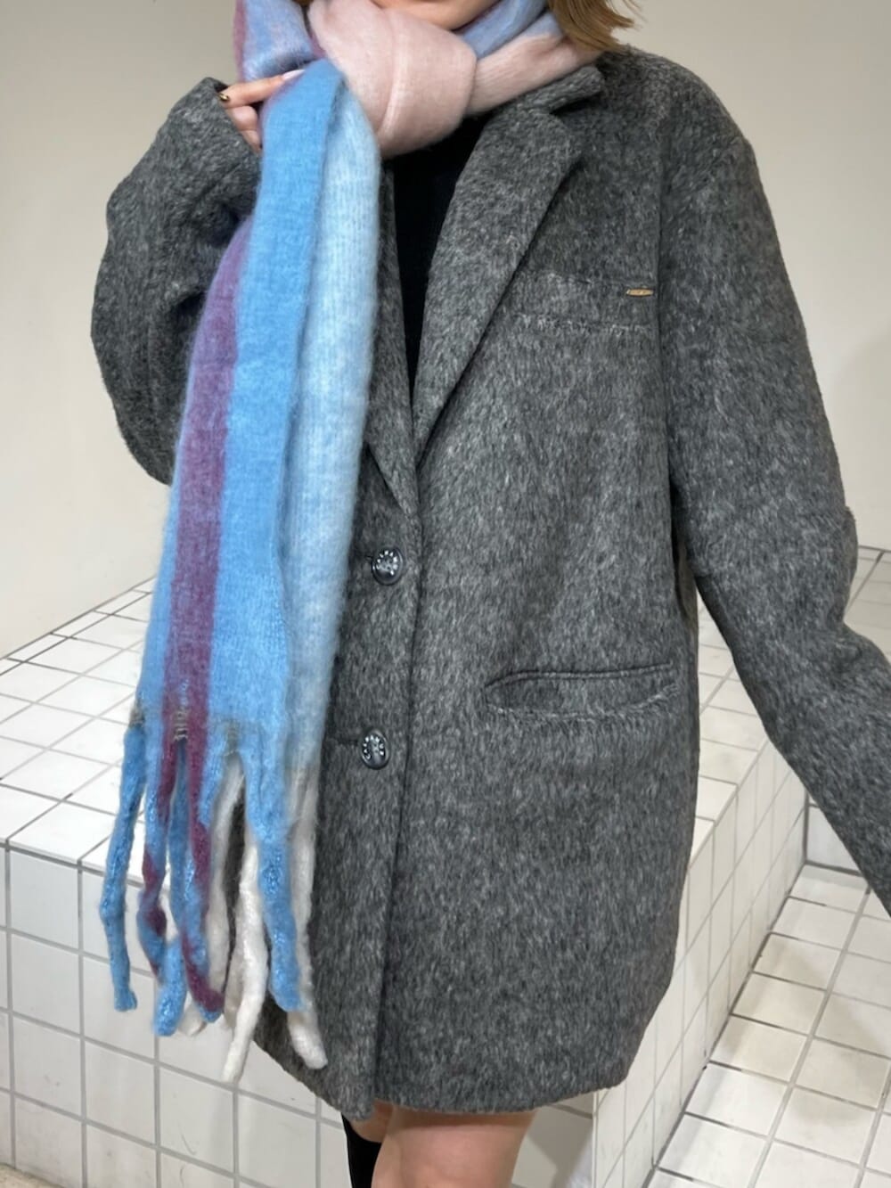 ブラック系のブーツ、グレー系のテーラードジャケット、その他のマフラーを着用したレディースの冬コーディネートの5枚目の写真