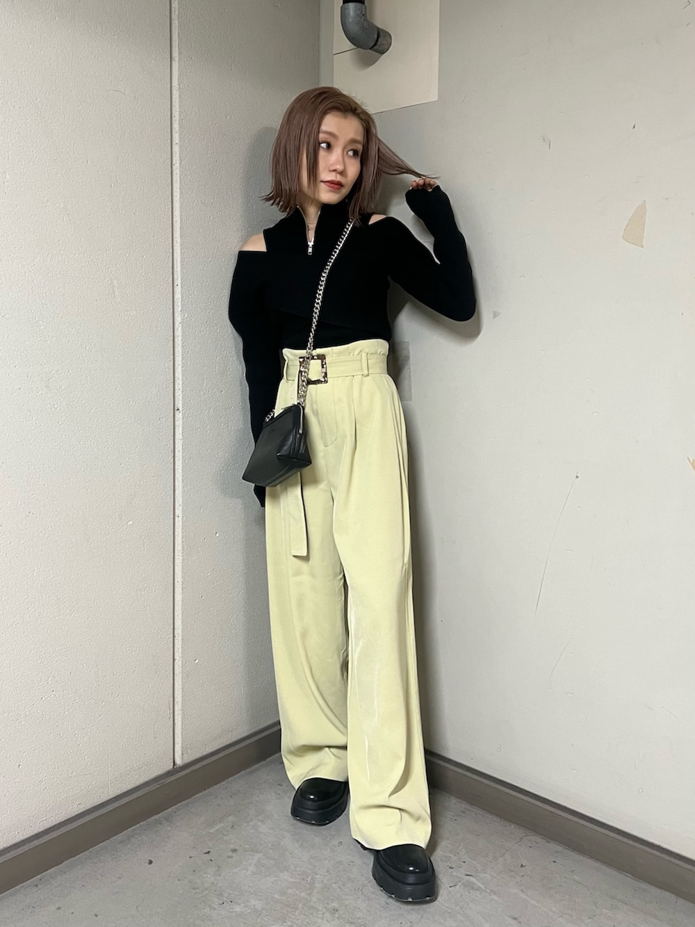 ブラック系のニット/セーター、ブラック系のハンドバッグ、ブラック系のブーツを着用したレディースの冬コーディネートの4枚目の写真