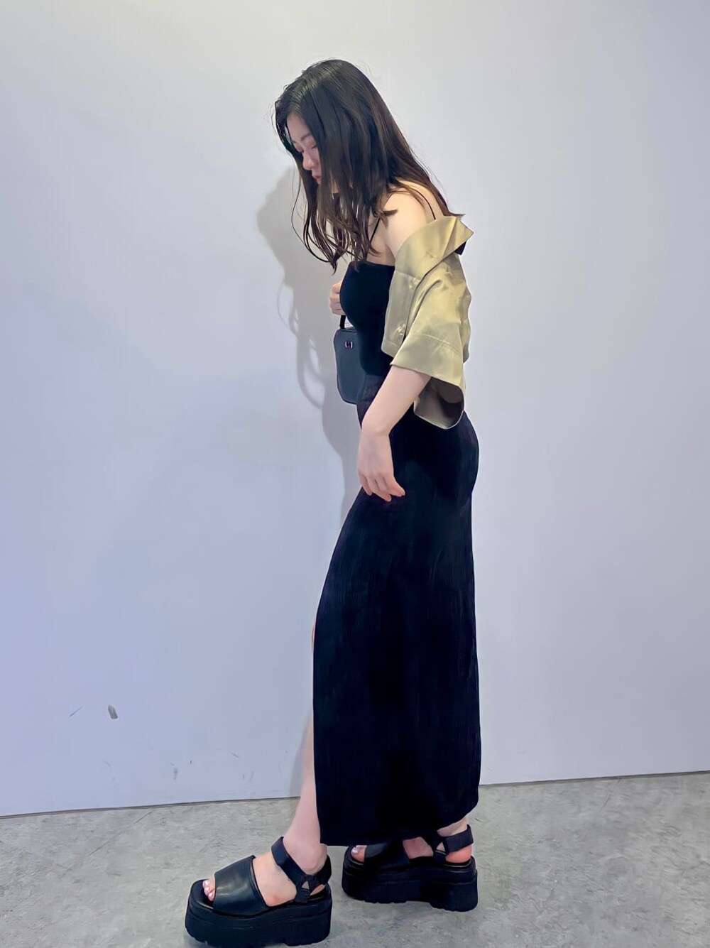 ブラック系のキャミソール、ブラック系のサンダル、ブラック系のショルダーバッグを着用したレディースの夏コーディネートの3枚目の写真