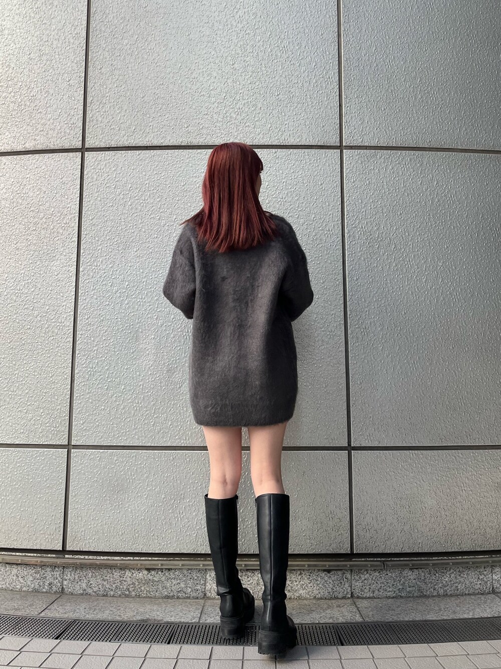 グレー系のカーディガン/ボレロ、グレー系のスカート、ブラック系のブーツを着用したレディースの秋コーディネートの5枚目の写真