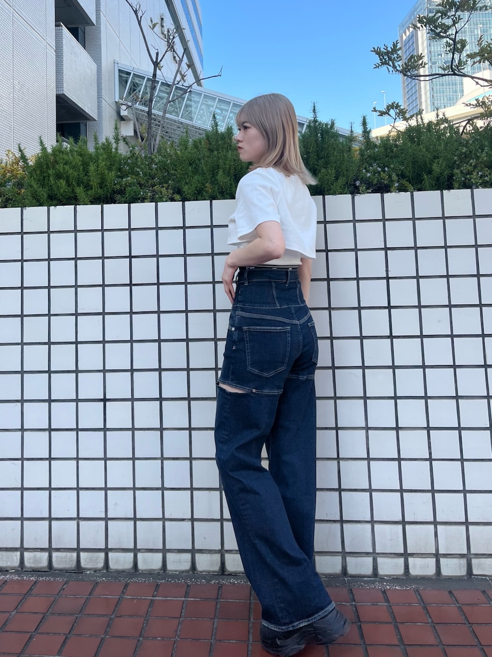 ブラック系のスニーカー、ブルー系のデニムパンツ、ホワイト系のTシャツ/カットソーを着用したレディースの春コーディネートの4枚目の写真