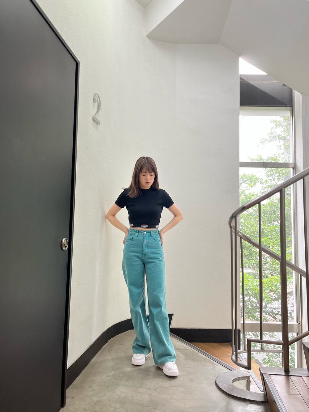 グリーン系のデニムパンツ、ブラック系のTシャツ/カットソー、ホワイト系のスニーカーを着用したレディースの夏コーディネートの6枚目の写真