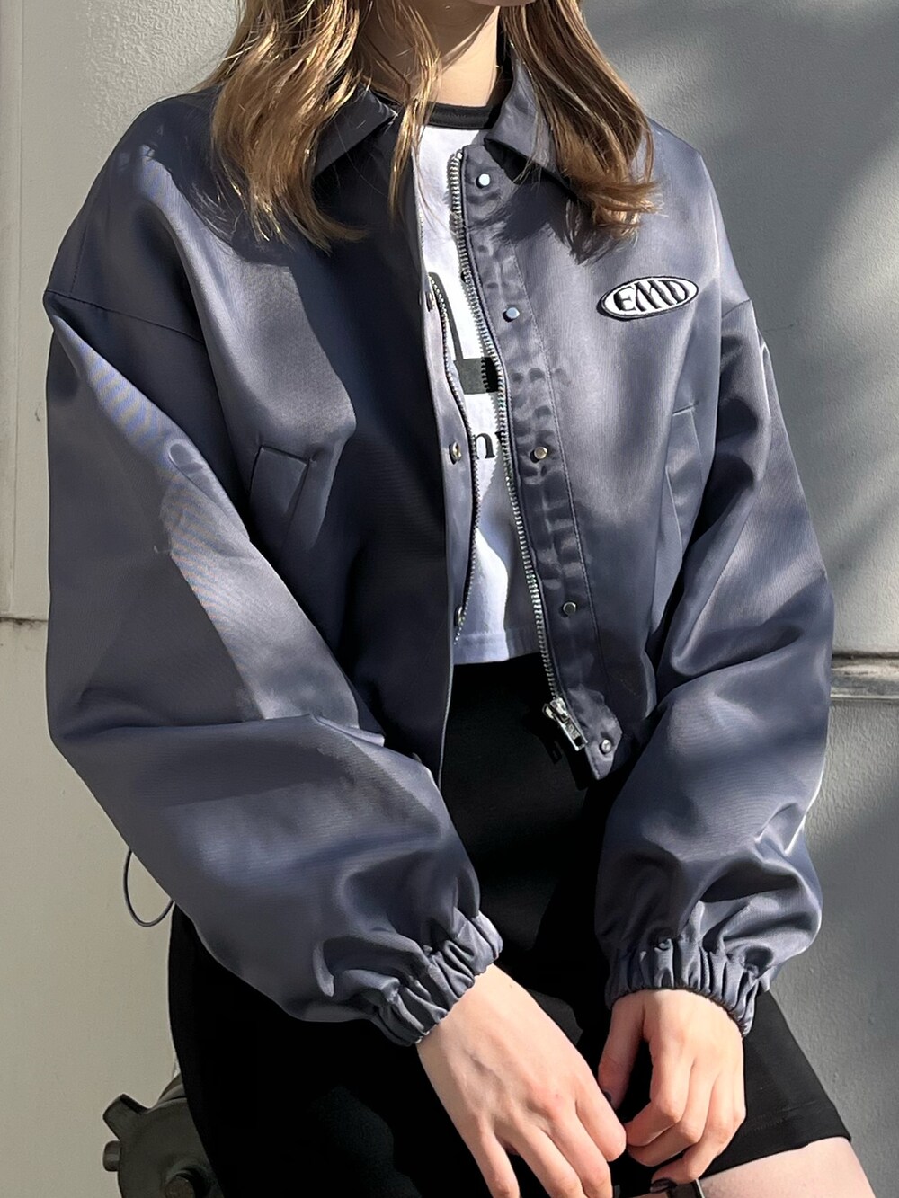 ブラック系のスカート、ブラック系のブーツ、ブラック系のハンドバッグを着用したレディースの冬コーディネートの4枚目の写真