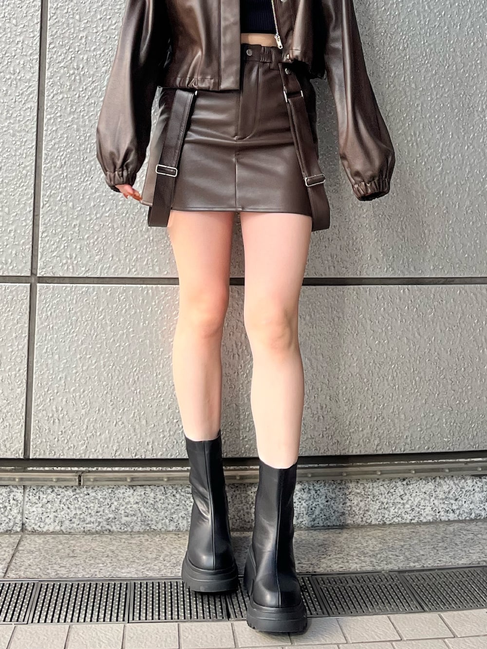 ブラウン系のスカート、ブラック系のニット/セーター、ブラウン系のブルゾンを着用したレディースの冬コーディネートの5枚目の写真