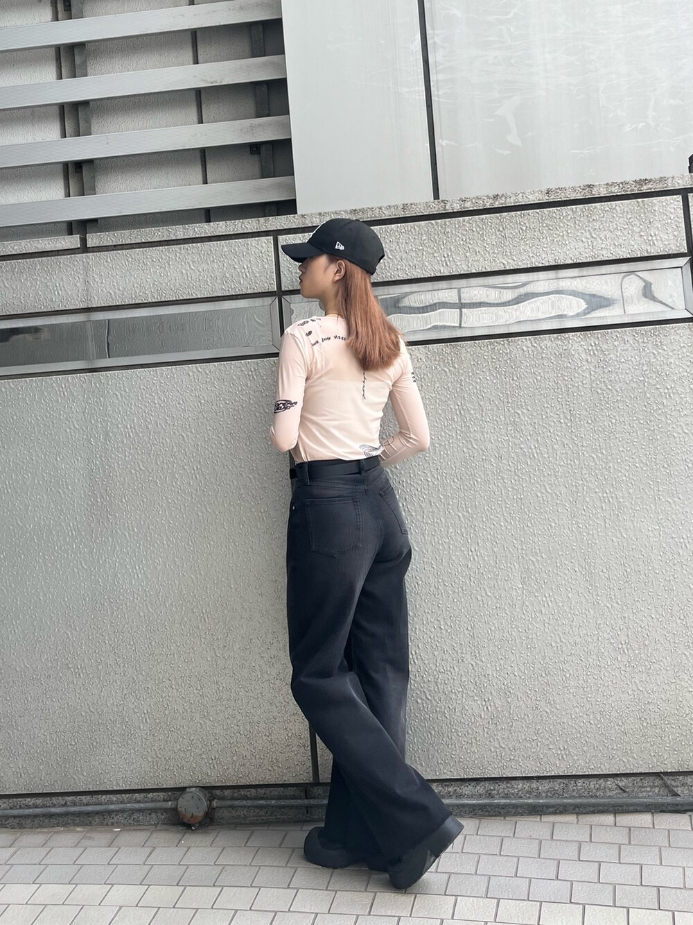 ブラック系のブーツ、ブラック系のデニムパンツ、ホワイト系のTシャツ/カットソーを着用したレディースの秋コーディネートの4枚目の写真