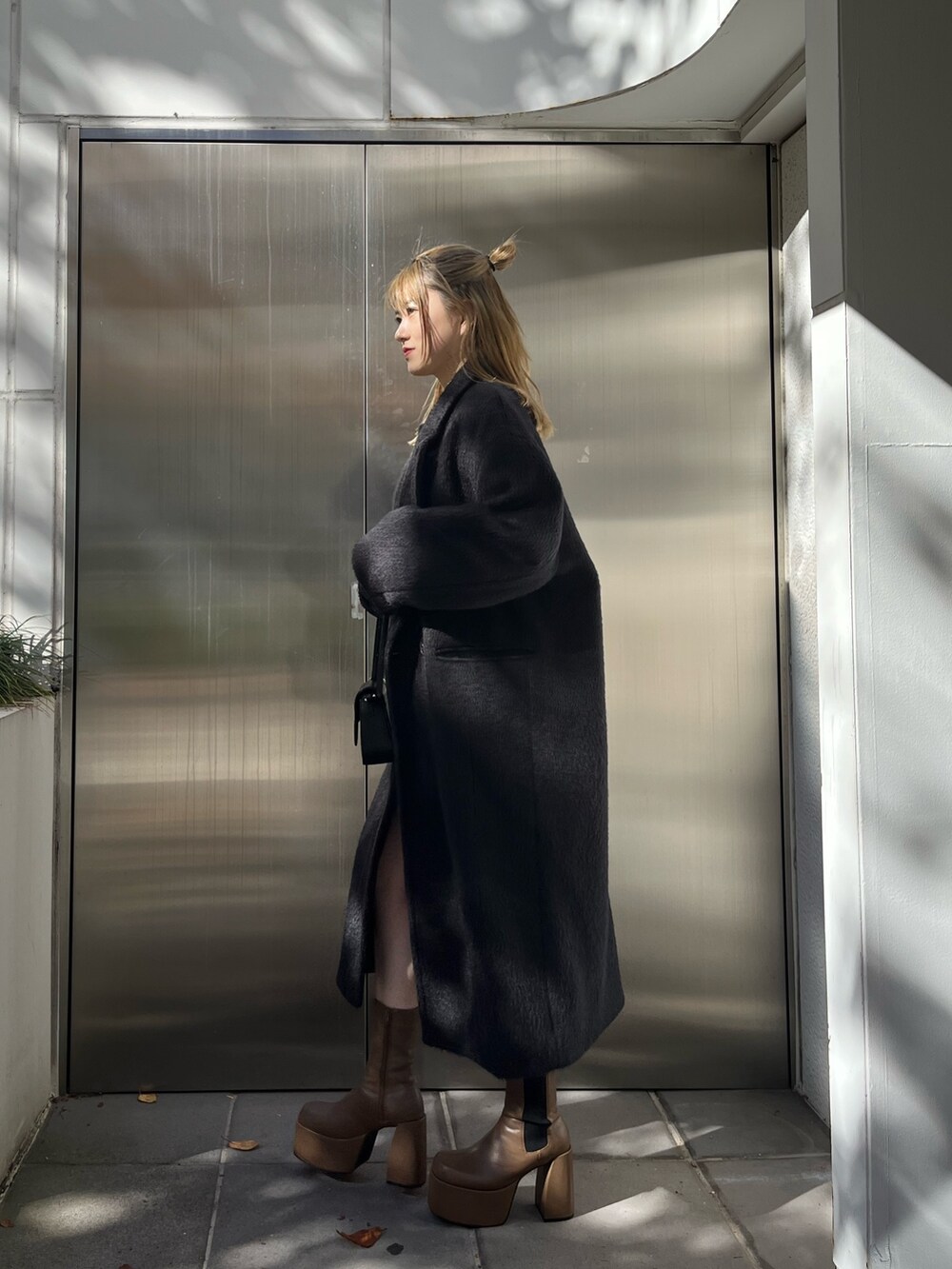 その他のニット/セーター、ブラック系のスカート、ブラウン系のブーツを着用したレディースの冬コーディネートの3枚目の写真