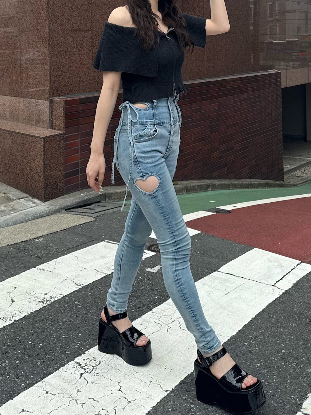 ブルー系のデニムパンツ、ブラック系のサンダル、ブラック系のニット/セーターを着用したレディースの春コーディネートの3枚目の写真