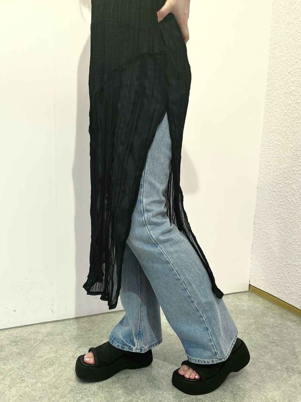 ホワイト系のタンクトップ、ブラック系のワンピース、ブルー系のデニムパンツを着用したレディースの夏コーディネートの6枚目の写真