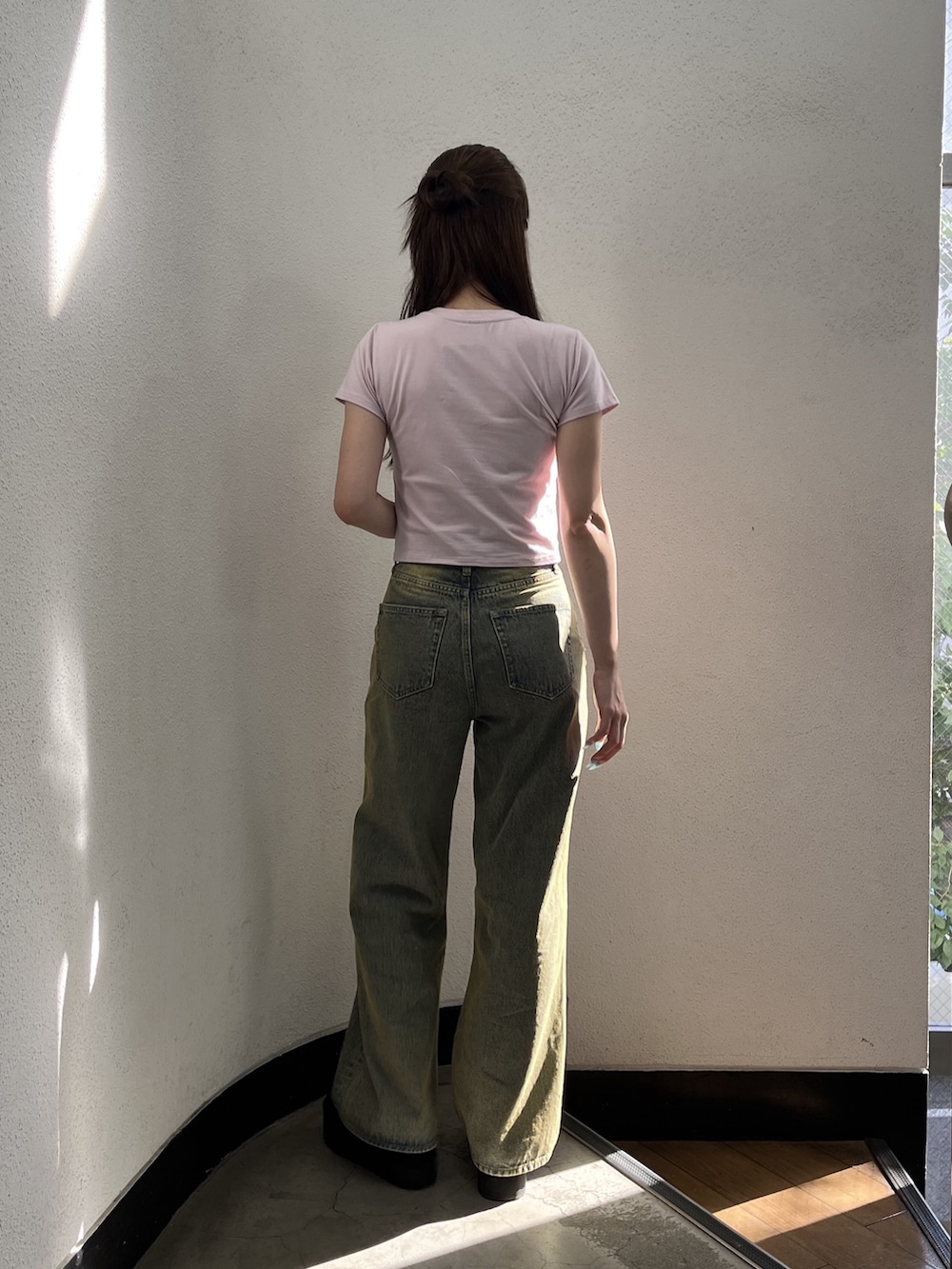 ブラック系のスリッポン、ブルー系のデニムパンツ、ピンク系のTシャツ/カットソーを着用したレディースの夏コーディネートの3枚目の写真