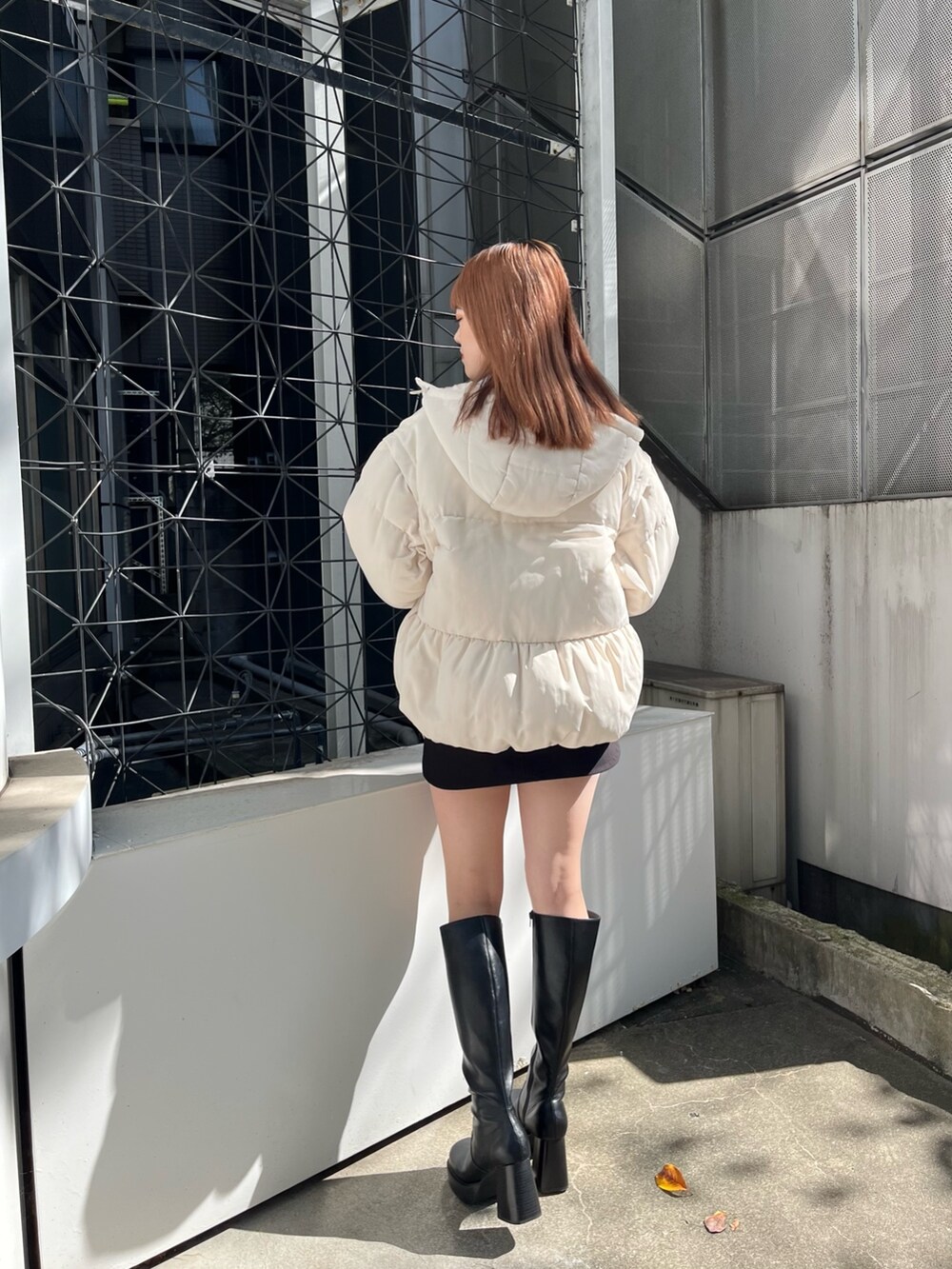 グレー系のスウェット、ホワイト系のブルゾン、ブラック系のスカートを着用したレディースの秋コーディネートの2枚目の写真