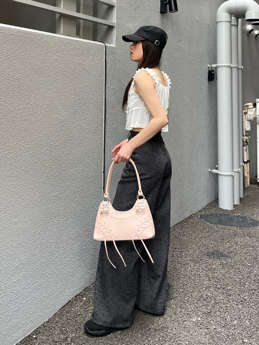 ピンク系のショルダーバッグ、グレー系のその他パンツ、ブラック系のスニーカーを着用したレディースの夏コーディネートの3枚目の写真