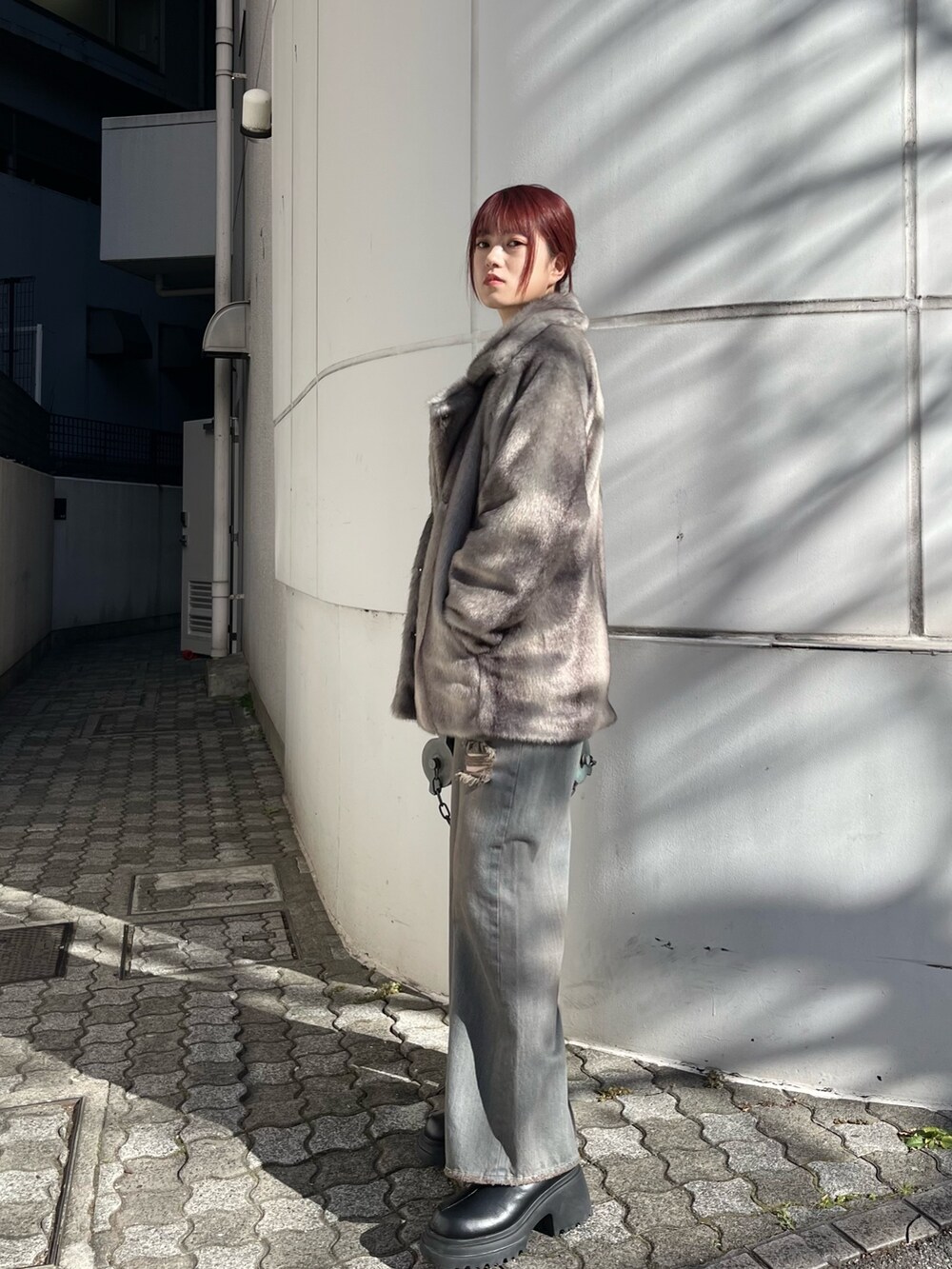 グレー系のその他アウター、グレー系のデニムパンツ、ブラック系のニット/セーターを着用したレディースの冬コーディネートの2枚目の写真