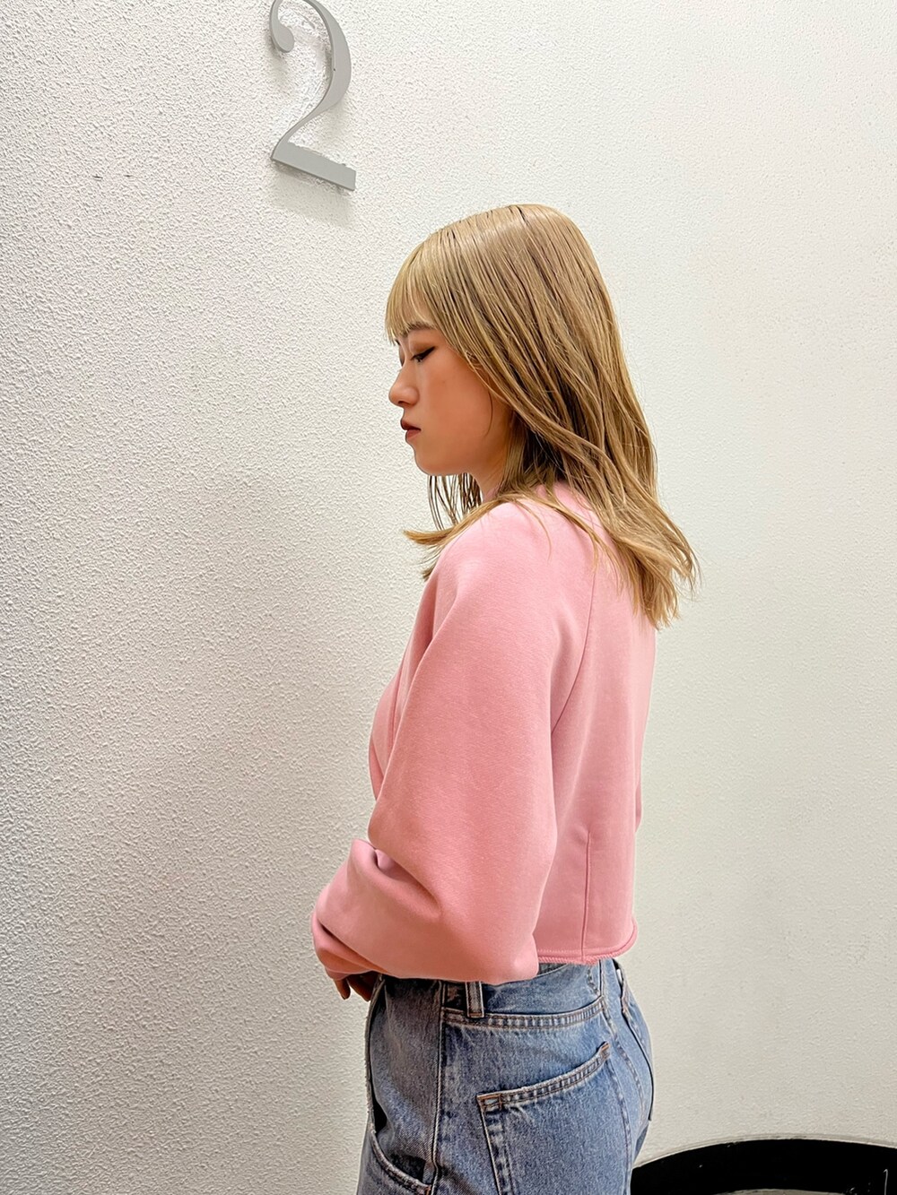 ブルー系のデニムパンツ、ブラック系のブーツ、ピンク系のスウェットを着用したレディースの冬コーディネートの5枚目の写真