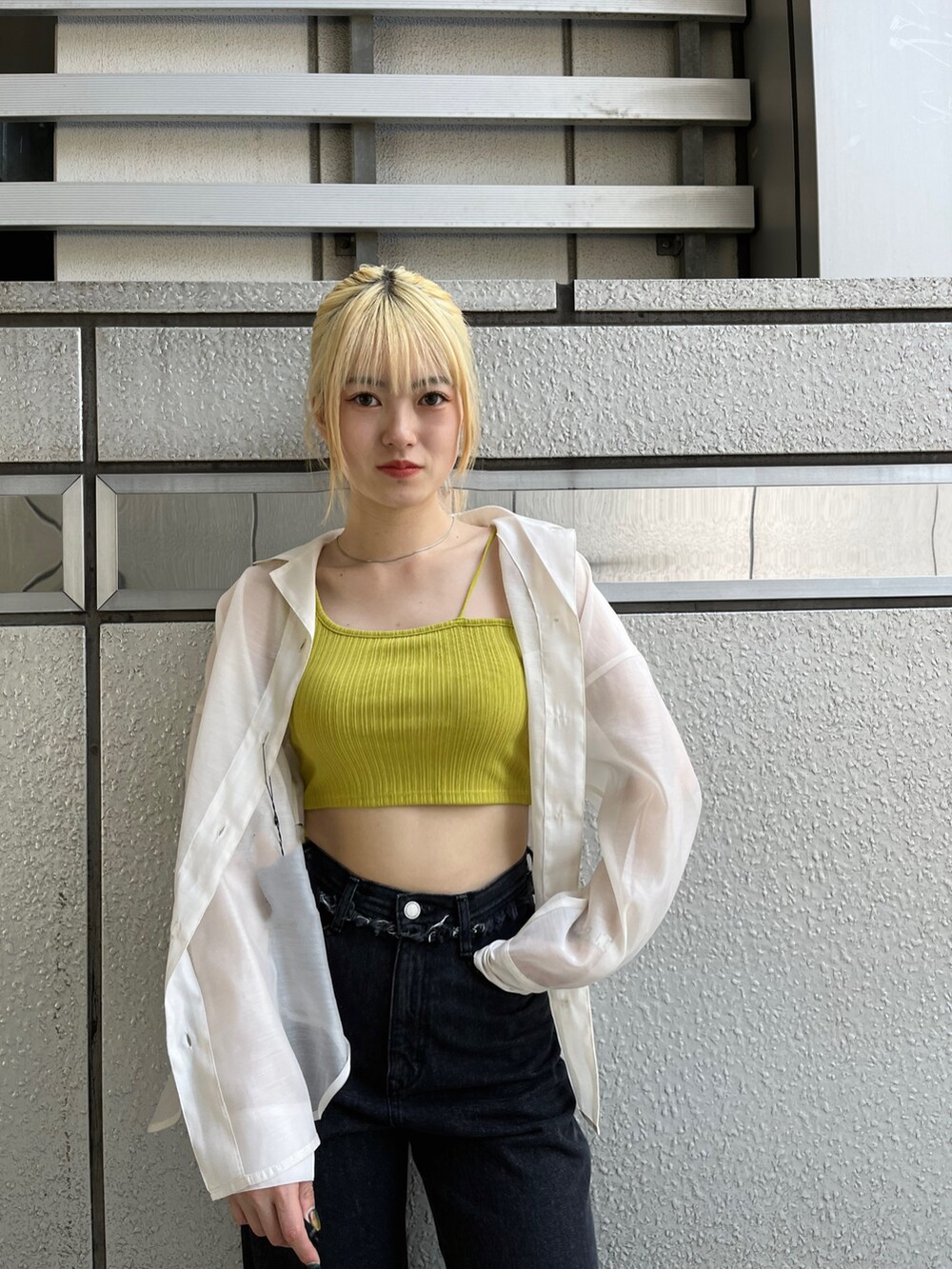 ブラック系のデニムパンツ、ブラック系のサンダル、イエロー系のタンクトップを着用したレディースの春コーディネートの6枚目の写真