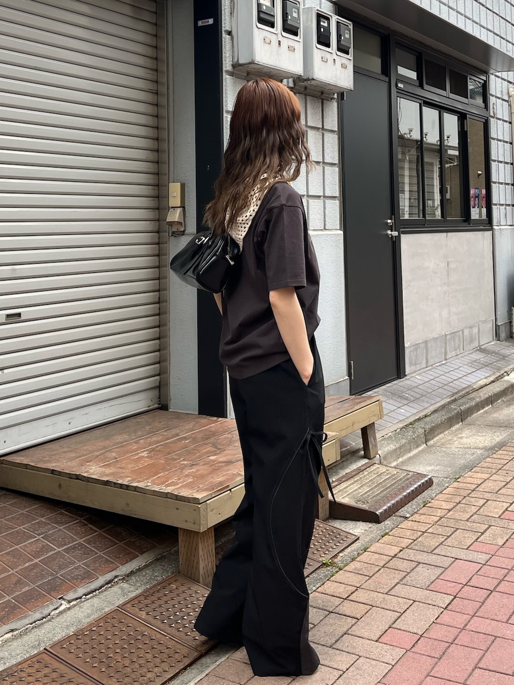 グレー系のTシャツ/カットソー、ブラック系のハンドバッグ、レッド系のスニーカーを着用したレディースの春コーディネートの3枚目の写真