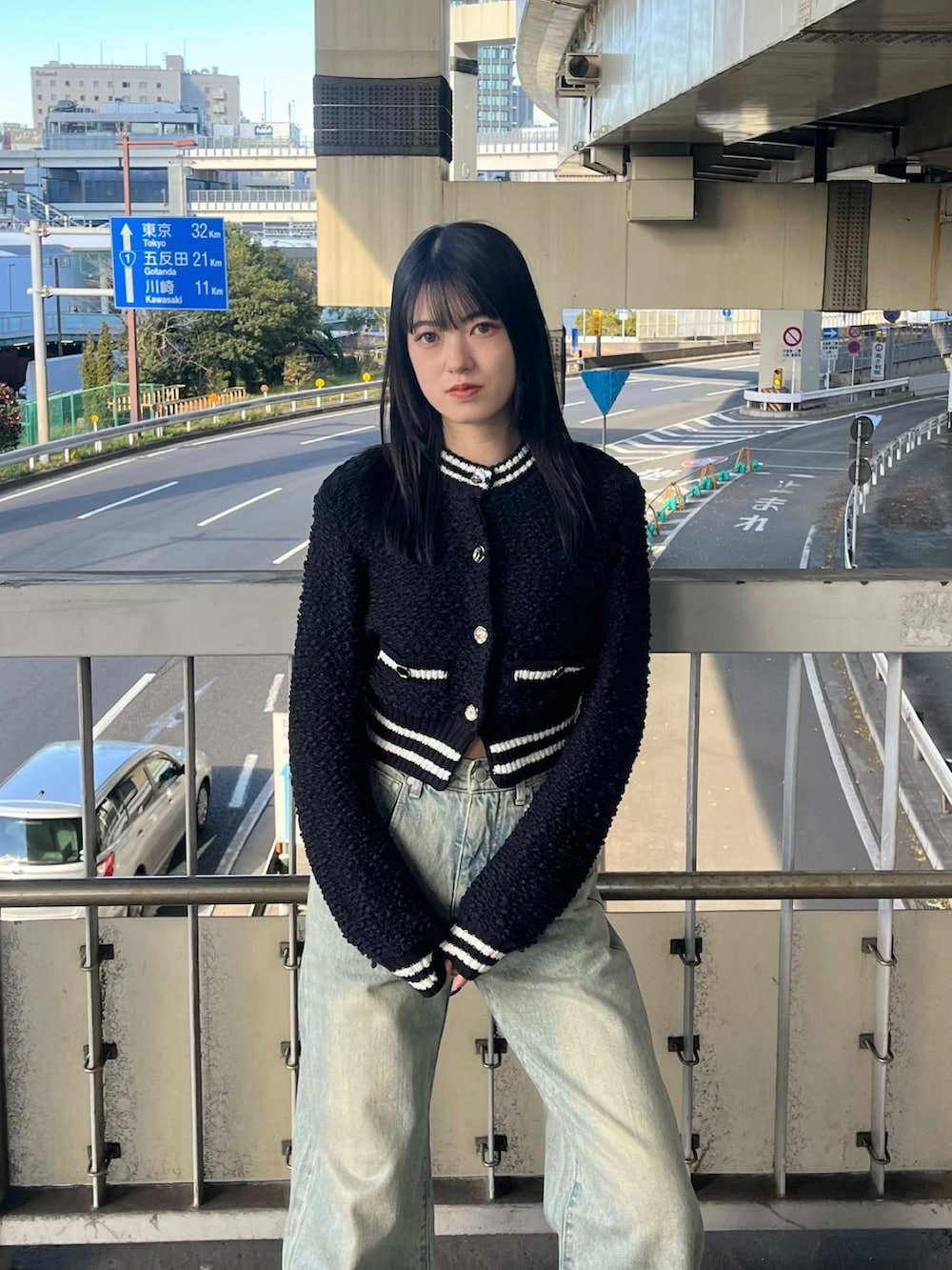 ブルー系のデニムパンツ、ブラック系のブーツ、ブラック系のカーディガン/ボレロを着用したレディースの冬コーディネートの7枚目の写真