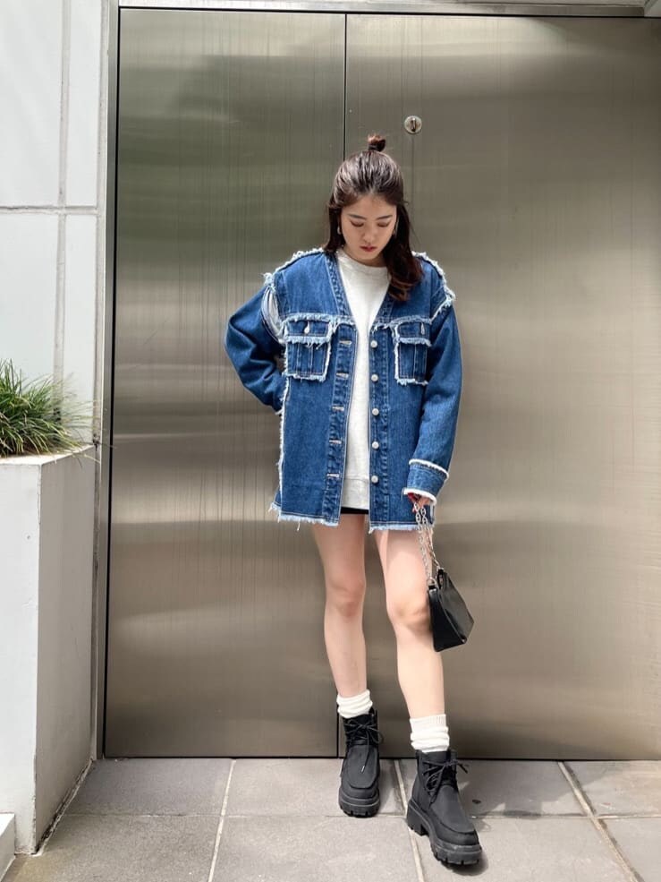 グレー系のスウェット、ブルー系のデニムジャケット、ブラック系のブーツを着用したレディースの秋コーディネートの2枚目の写真