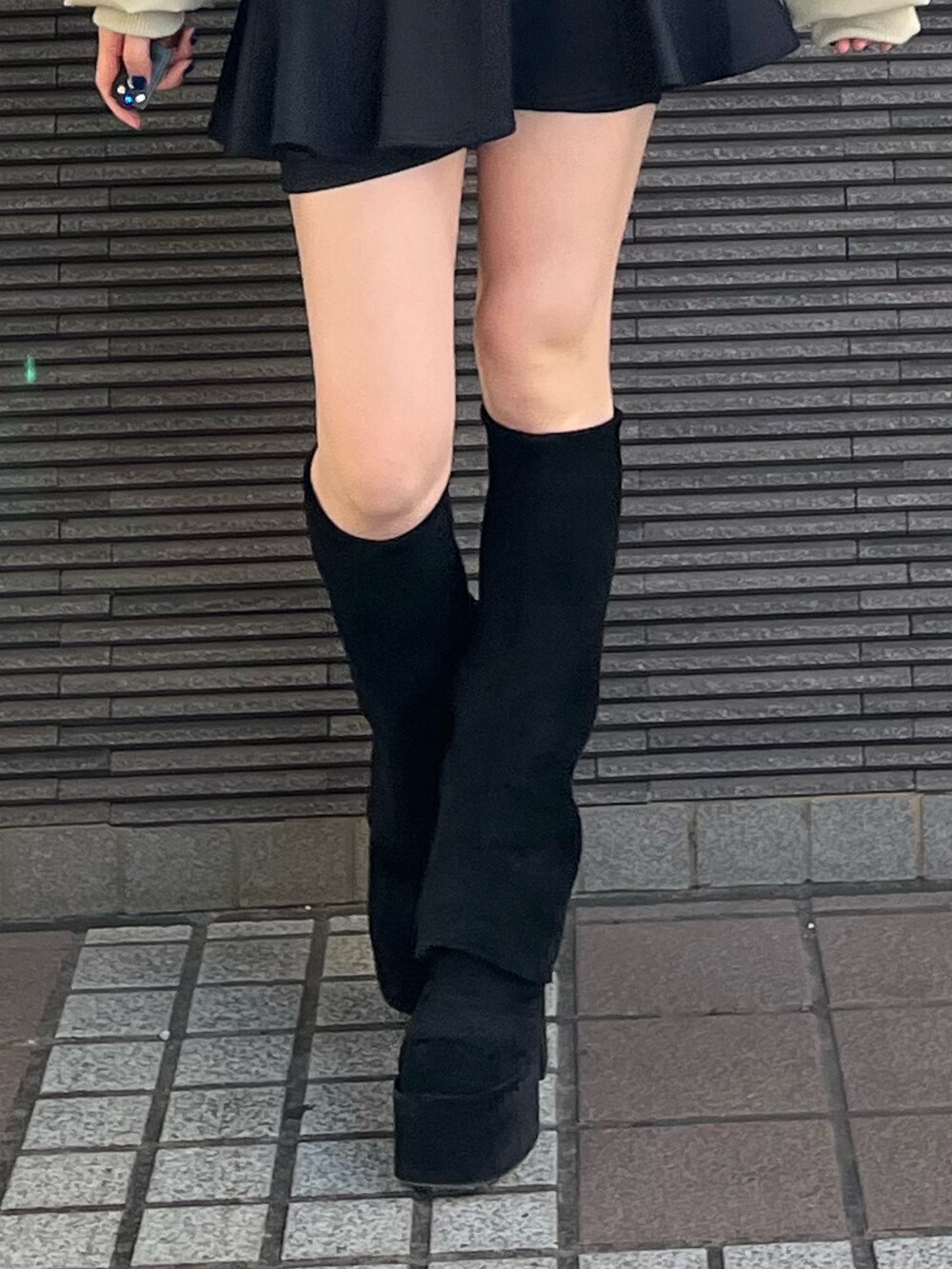 ブラック系のスカート、ブラック系のブーツ、ブラック系のニット/セーターを着用したレディースの冬コーディネートの7枚目の写真