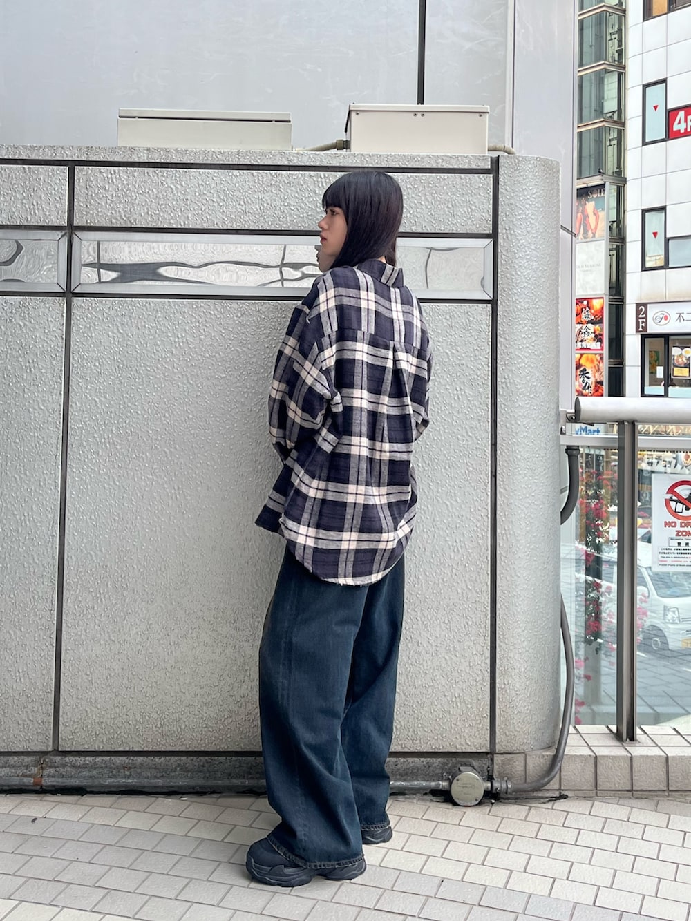 ブラック系のシャツ/ブラウス、ブルー系のデニムパンツを着用したレディースの秋コーディネートの4枚目の写真