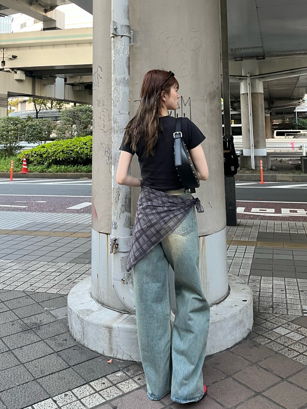 ブラック系のTシャツ/カットソー、ブラック系のハンドバッグ、ブルー系のデニムパンツを着用したレディースの春コーディネートの3枚目の写真
