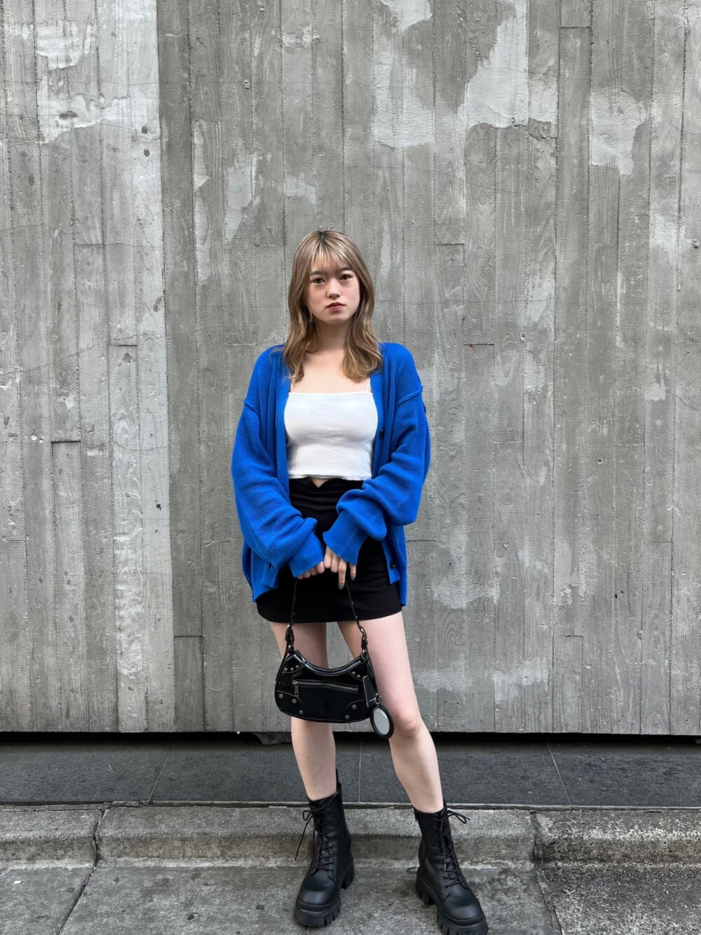 ブラック系のハンドバッグ、ブラック系のブーツ、ホワイト系のキャミソールを着用したレディースの春コーディネートの2枚目の写真