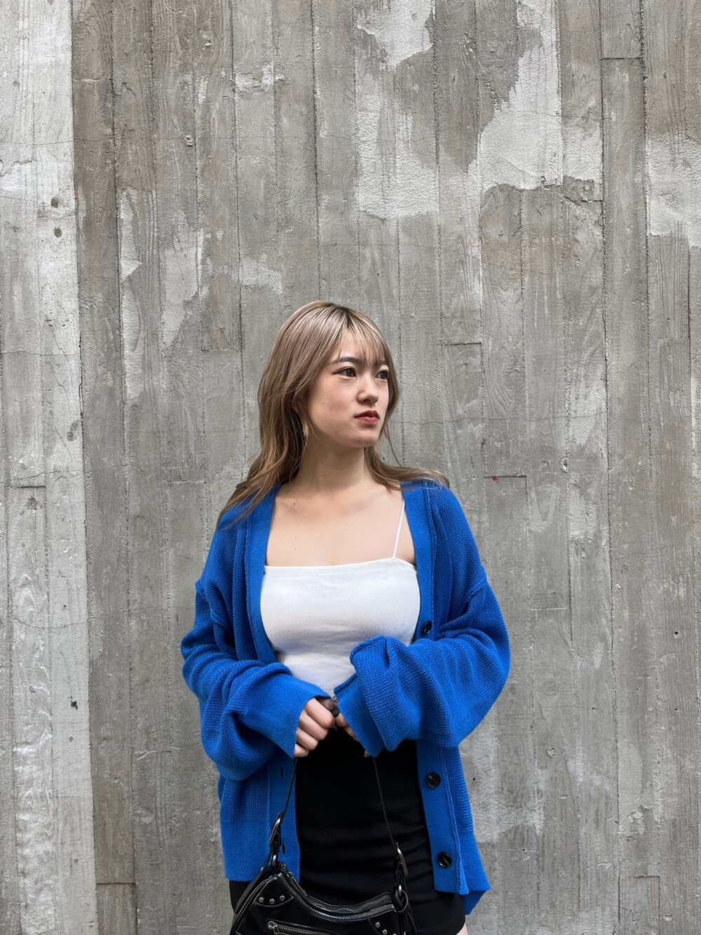 ブラック系のハンドバッグ、ブラック系のブーツ、ホワイト系のキャミソールを着用したレディースの春コーディネートの5枚目の写真