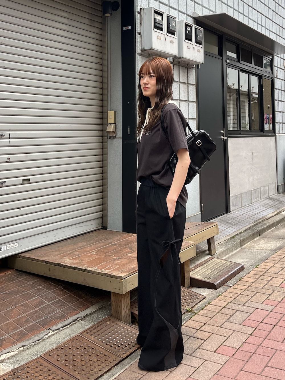 グレー系のTシャツ/カットソー、ブラック系のハンドバッグ、レッド系のスニーカーを着用したレディースの春コーディネートの2枚目の写真