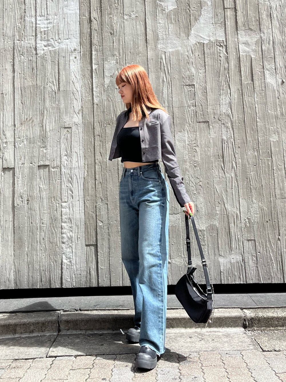 ブラック系のブーツ、ブラック系のキャミソール、ブルー系のデニムパンツを着用したレディースの夏コーディネートの5枚目の写真