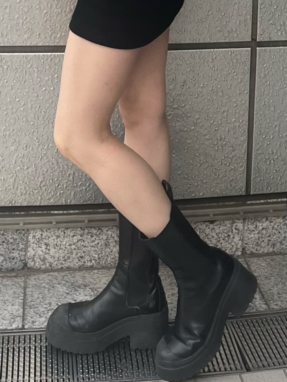 ブラック系のスカート、ブラック系のブーツ、ブラック系のブルゾンを着用したレディースの秋コーディネートの7枚目の写真