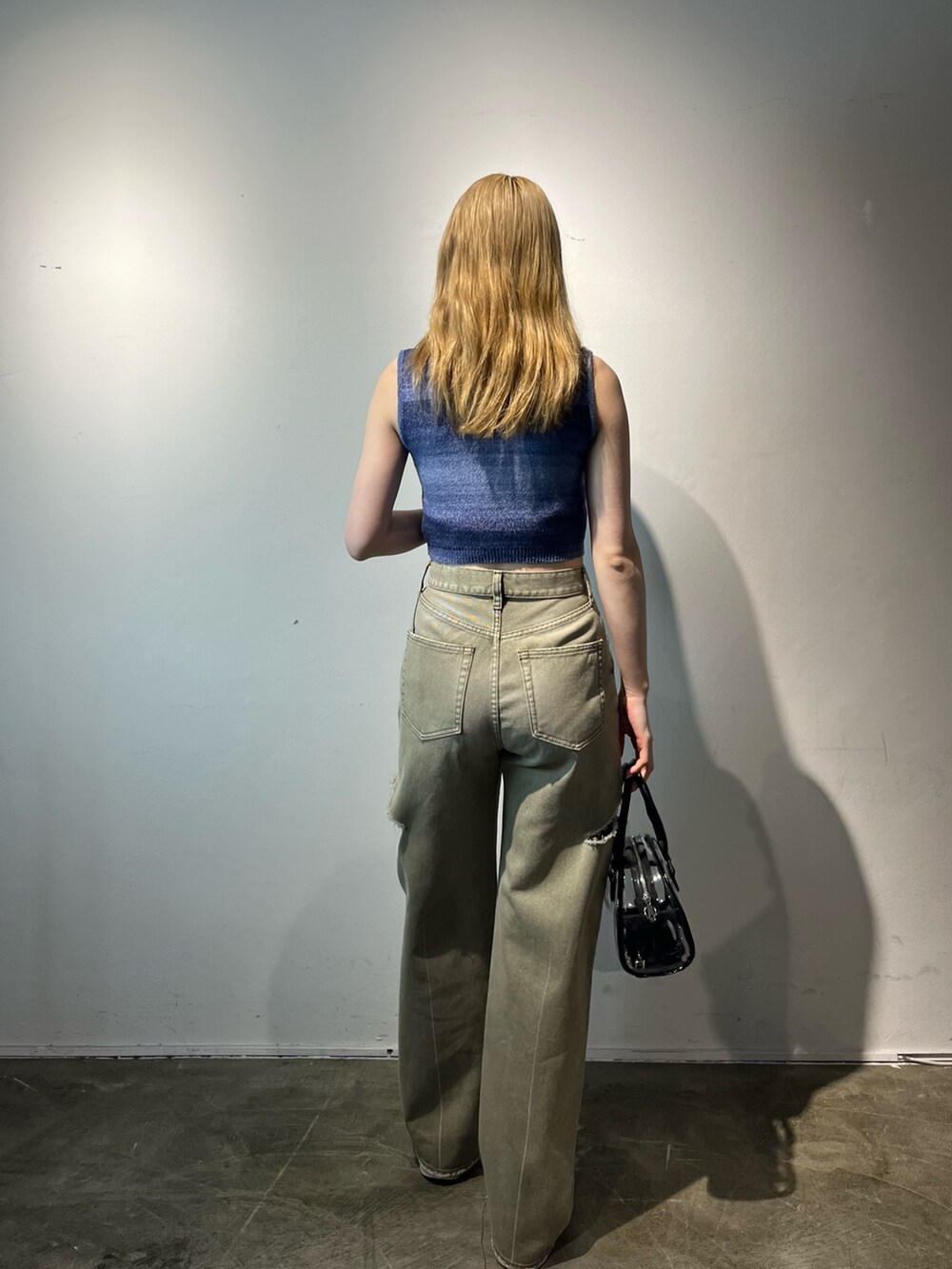 ベージュ系のデニムパンツ、その他のハンドバッグ、ブルー系のタンクトップを着用したレディースの春コーディネートの4枚目の写真