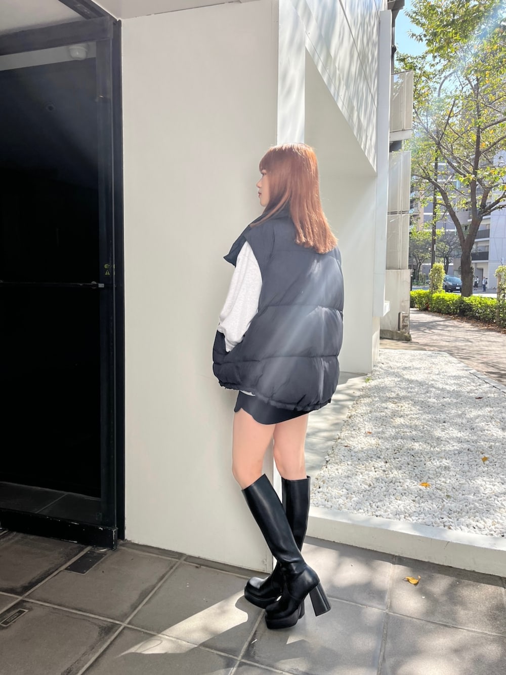 ブラック系のブーツ、グレー系のスウェット、ブラック系のスカートを着用したレディースの秋コーディネートの3枚目の写真