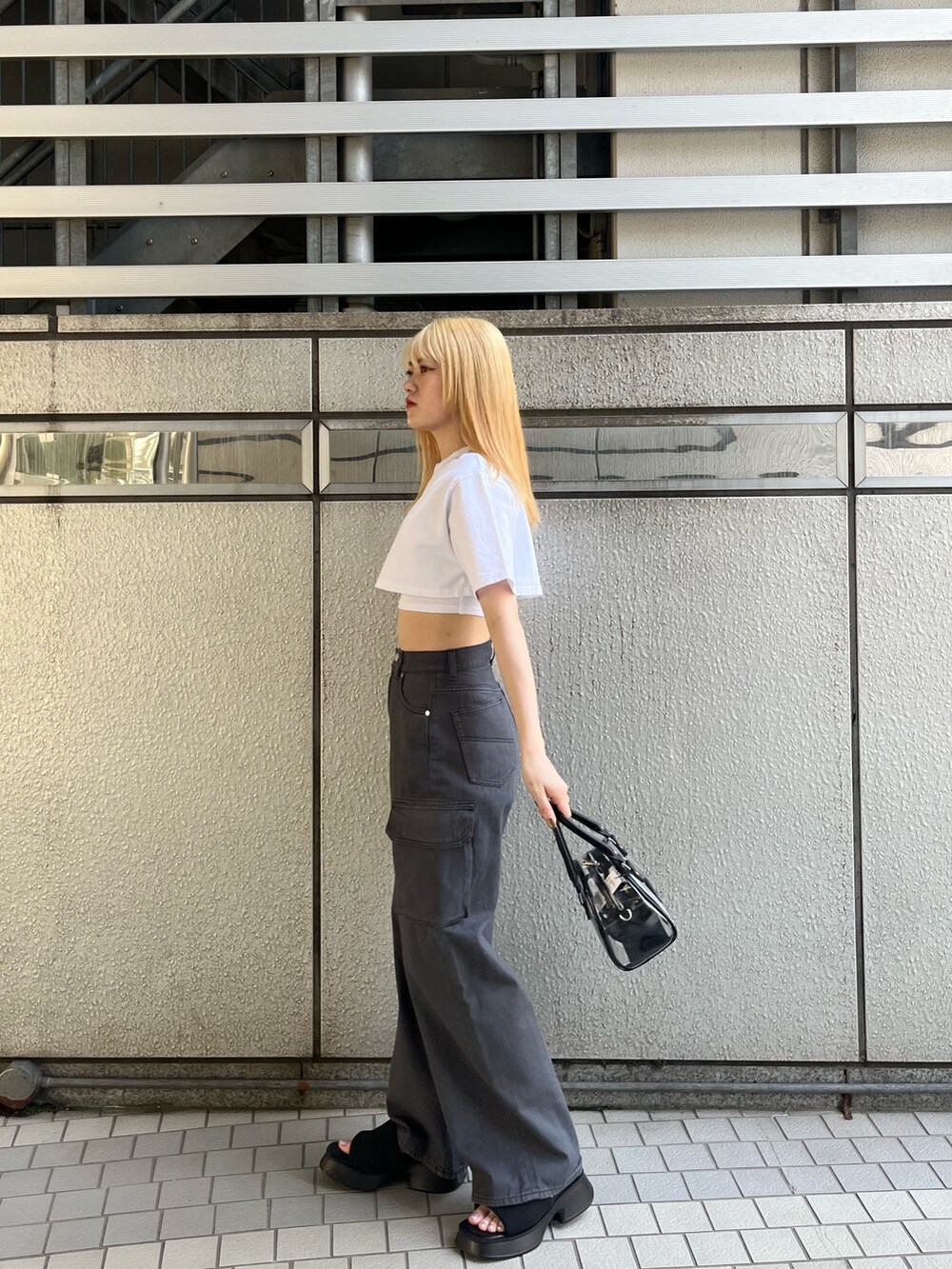 ホワイト系のTシャツ/カットソー、ブラック系のサンダル、ブラック系のデニムパンツを着用したレディースの春コーディネートの3枚目の写真