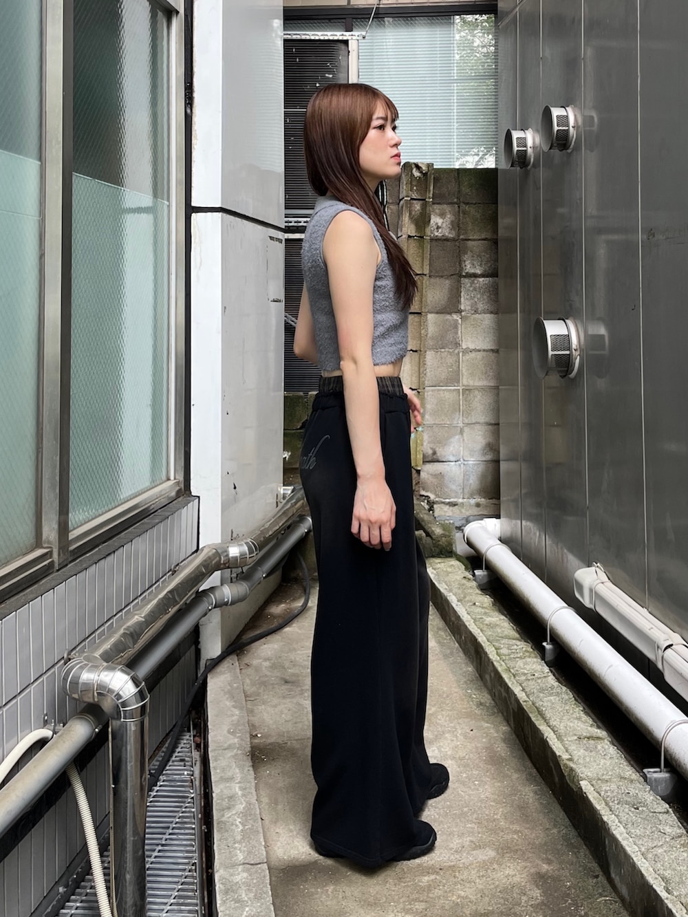 ブラック系のスニーカー、ブラック系のスウェットパンツ、グレー系のニット/セーターを着用したレディースの夏コーディネートの2枚目の写真