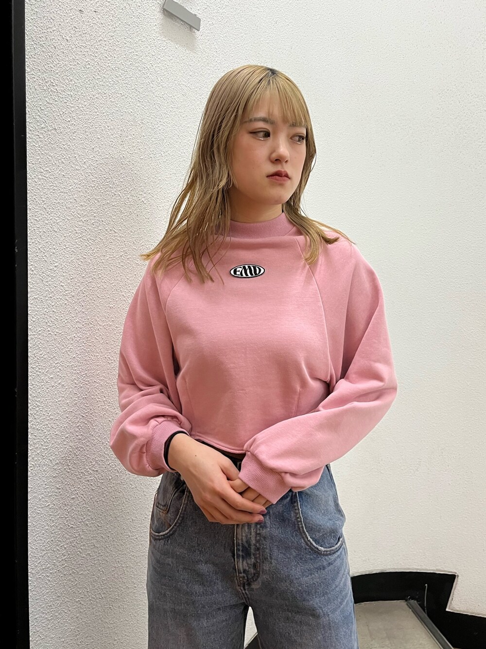 ブルー系のデニムパンツ、ブラック系のブーツ、ピンク系のスウェットを着用したレディースの冬コーディネートの4枚目の写真