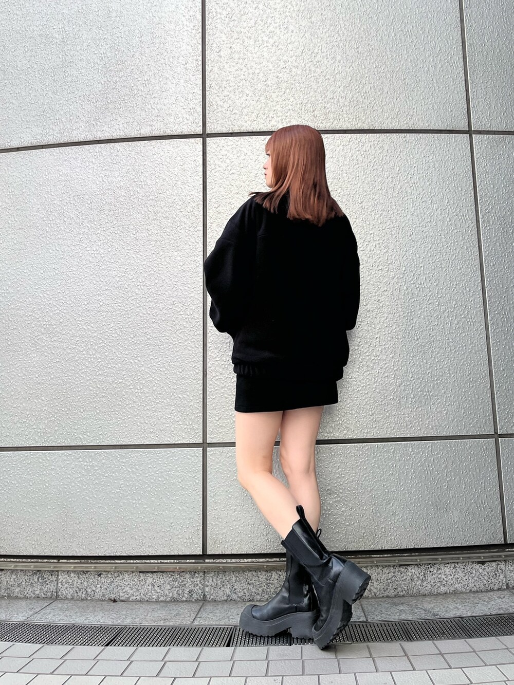 ブラック系のスカート、ブラック系のブーツ、ブラック系のブルゾンを着用したレディースの秋コーディネートの3枚目の写真