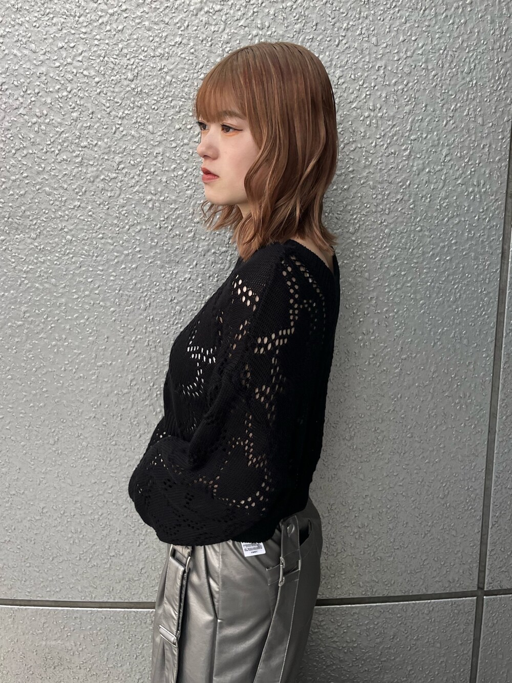 ブラック系のスニーカー、ブラック系のニット/セーター、ホワイト系のキャミソールを着用したレディースの冬コーディネートの7枚目の写真