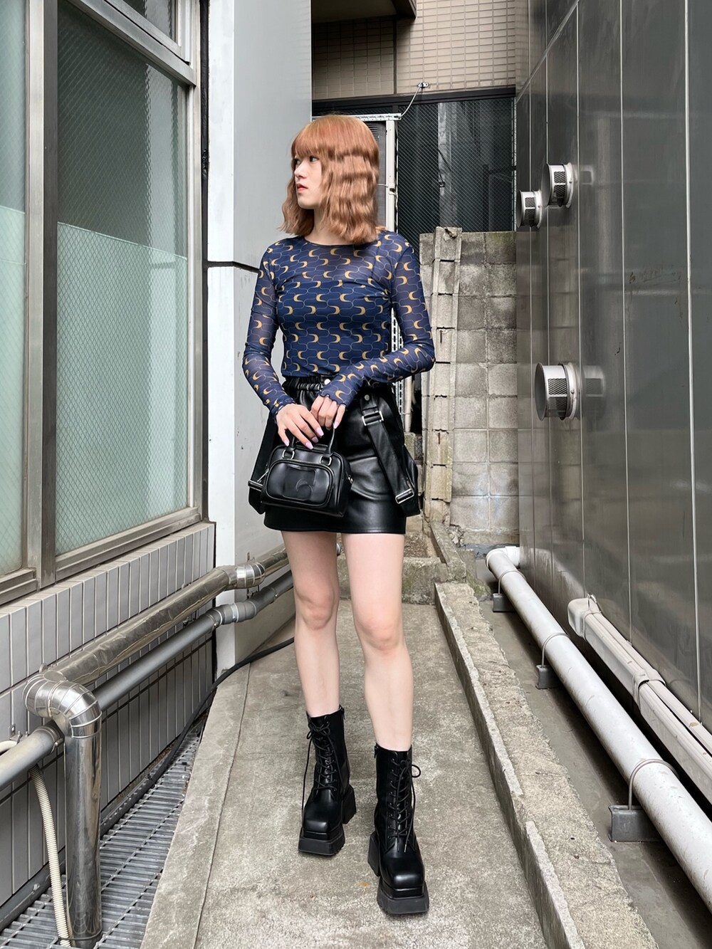 ブラック系のブーツ、ブラック系のスカート、その他のTシャツ/カットソーを着用したレディースの冬コーディネートの3枚目の写真