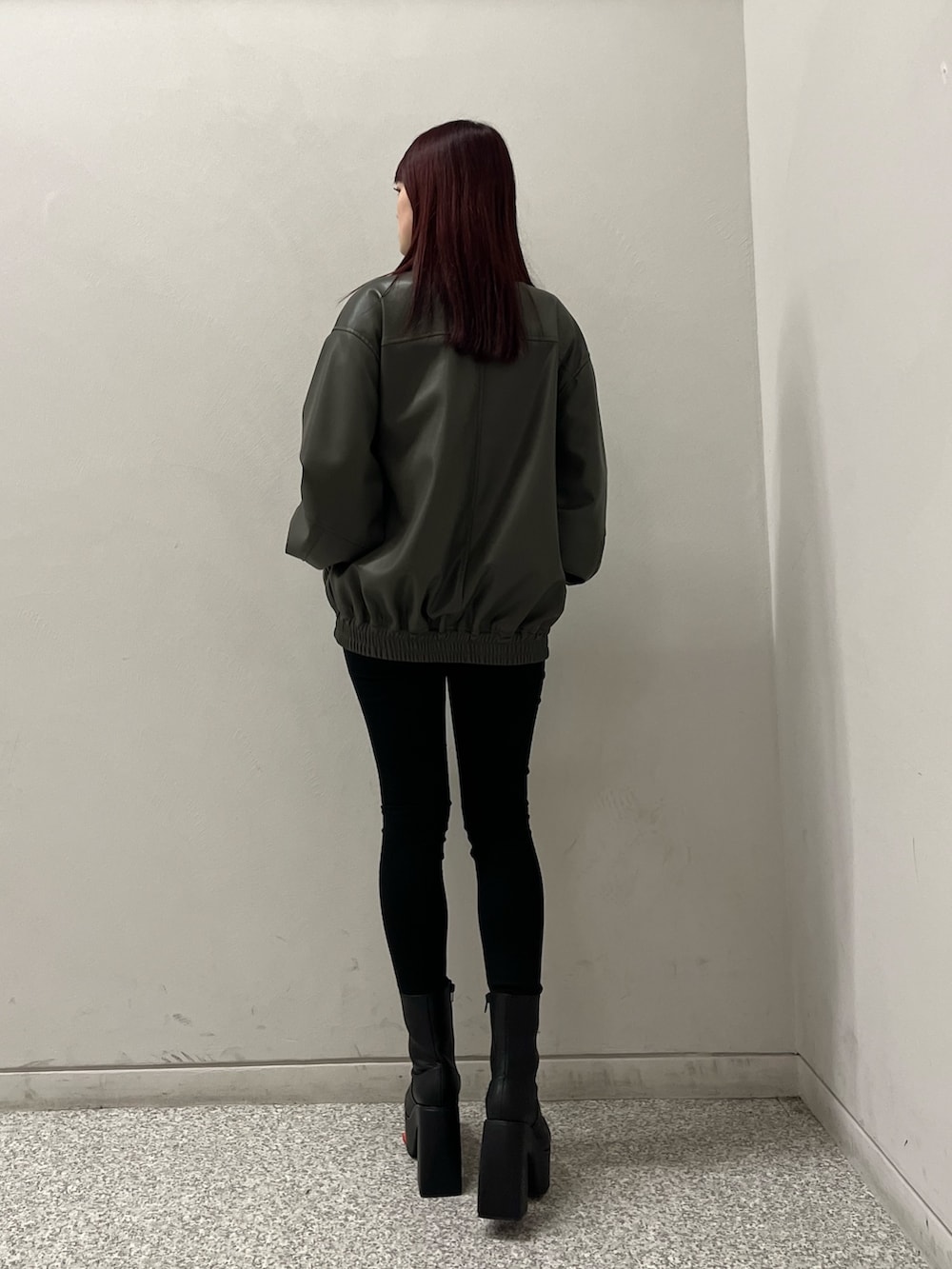 グレー系のブルゾン、ブラック系のデニムパンツ、ブラック系のニット/セーターを着用したレディースの冬コーディネートの4枚目の写真