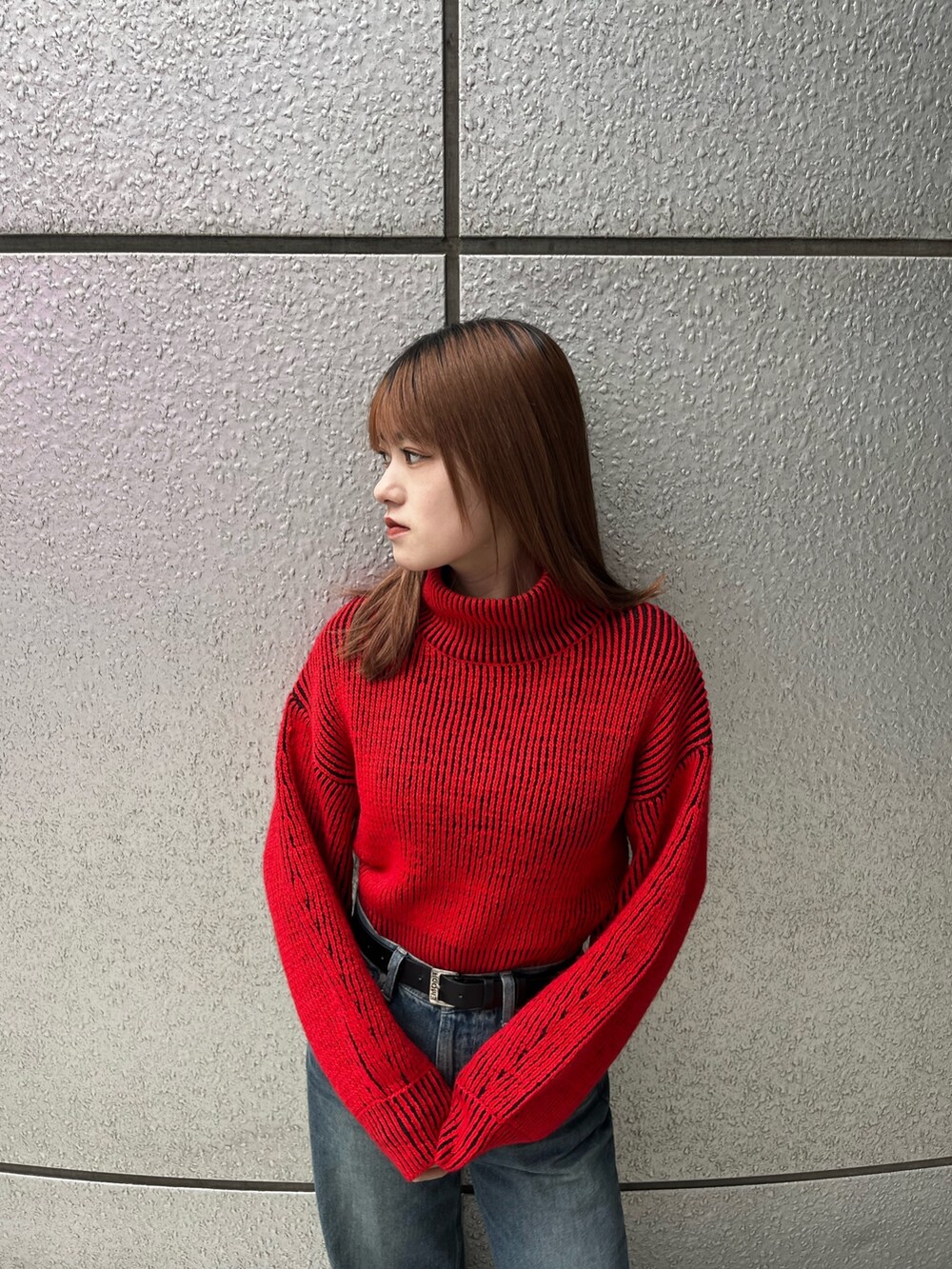 ブラック系のブーツ、ブルー系のデニムパンツ、レッド系のニット/セーターを着用したレディースの秋コーディネートの6枚目の写真