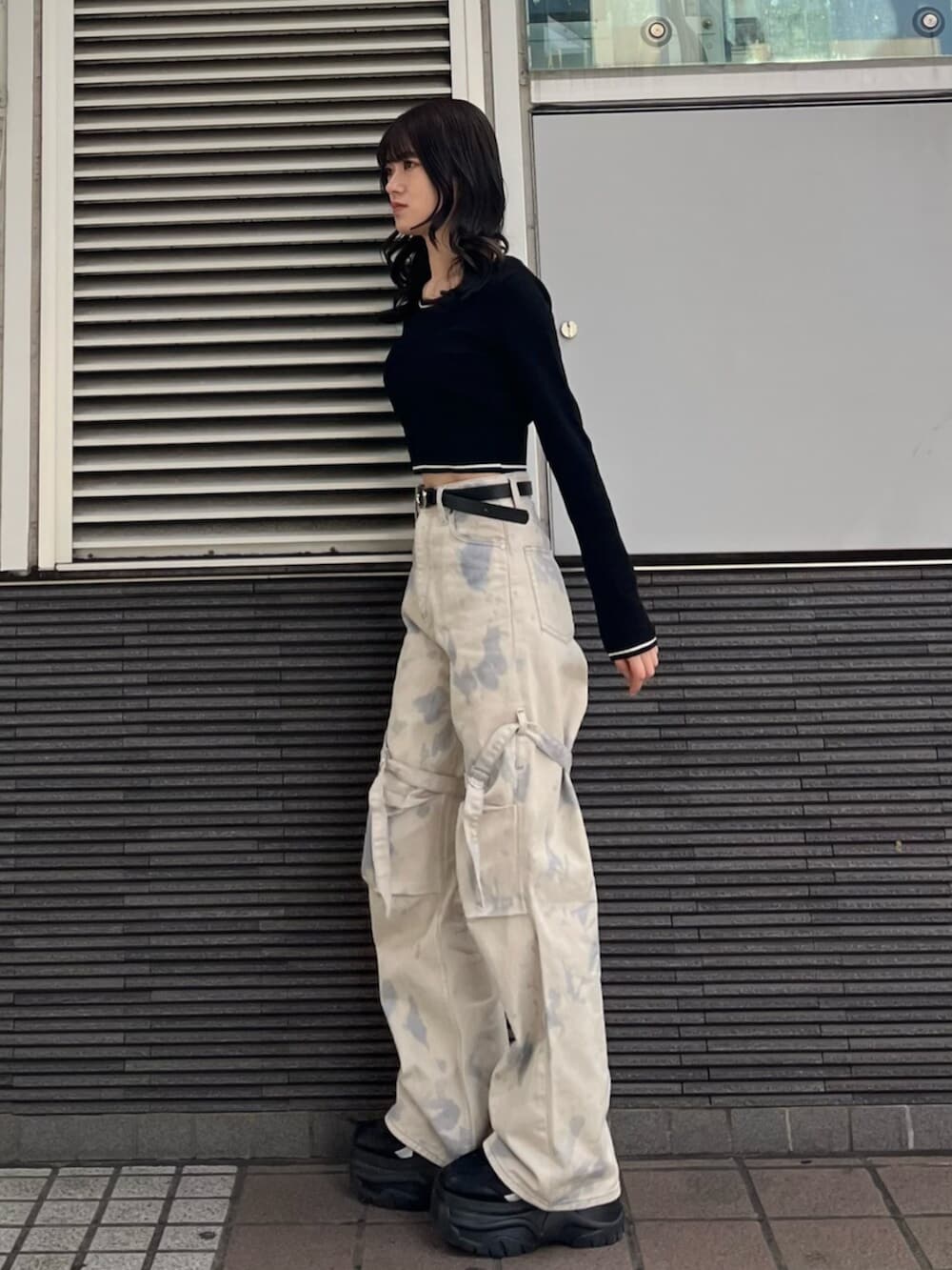 ブラック系のスニーカー、ホワイト系のデニムパンツ、ブラック系のニット/セーターを着用したレディースの冬コーディネートの3枚目の写真