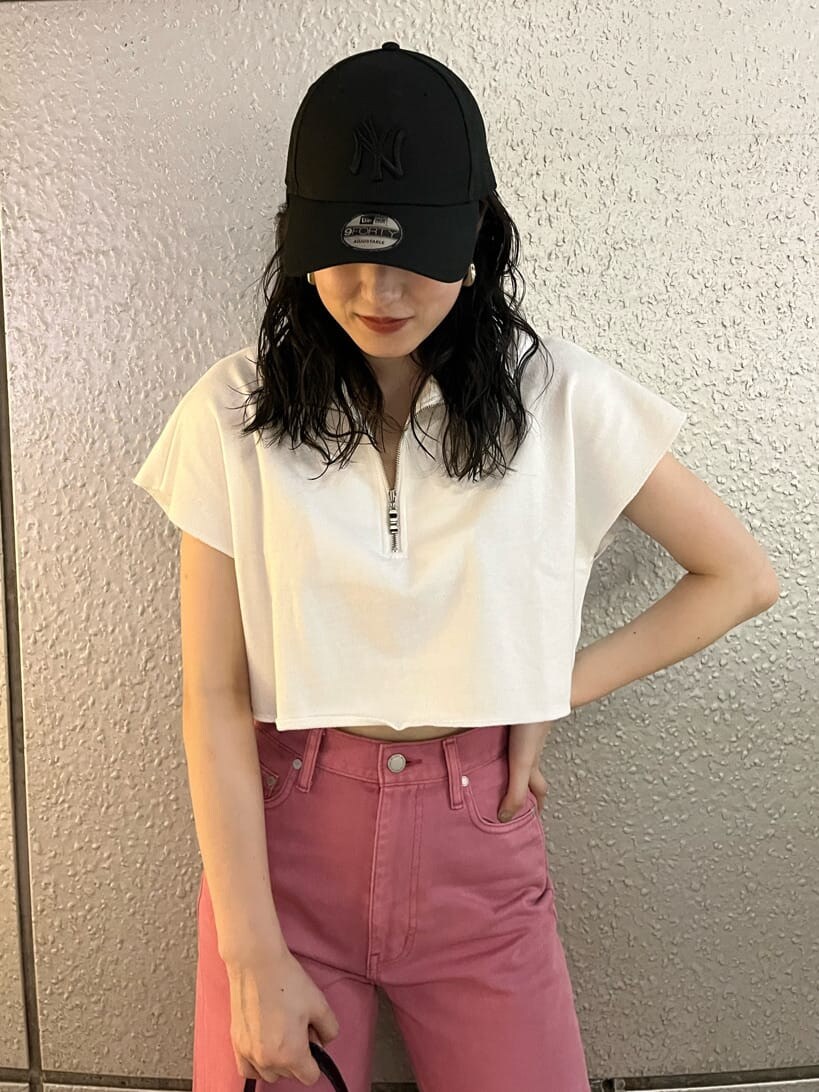 ピンク系のデニムパンツ、ブラック系のサンダル、ブラック系のハンドバッグを着用したレディースの夏コーディネートの5枚目の写真