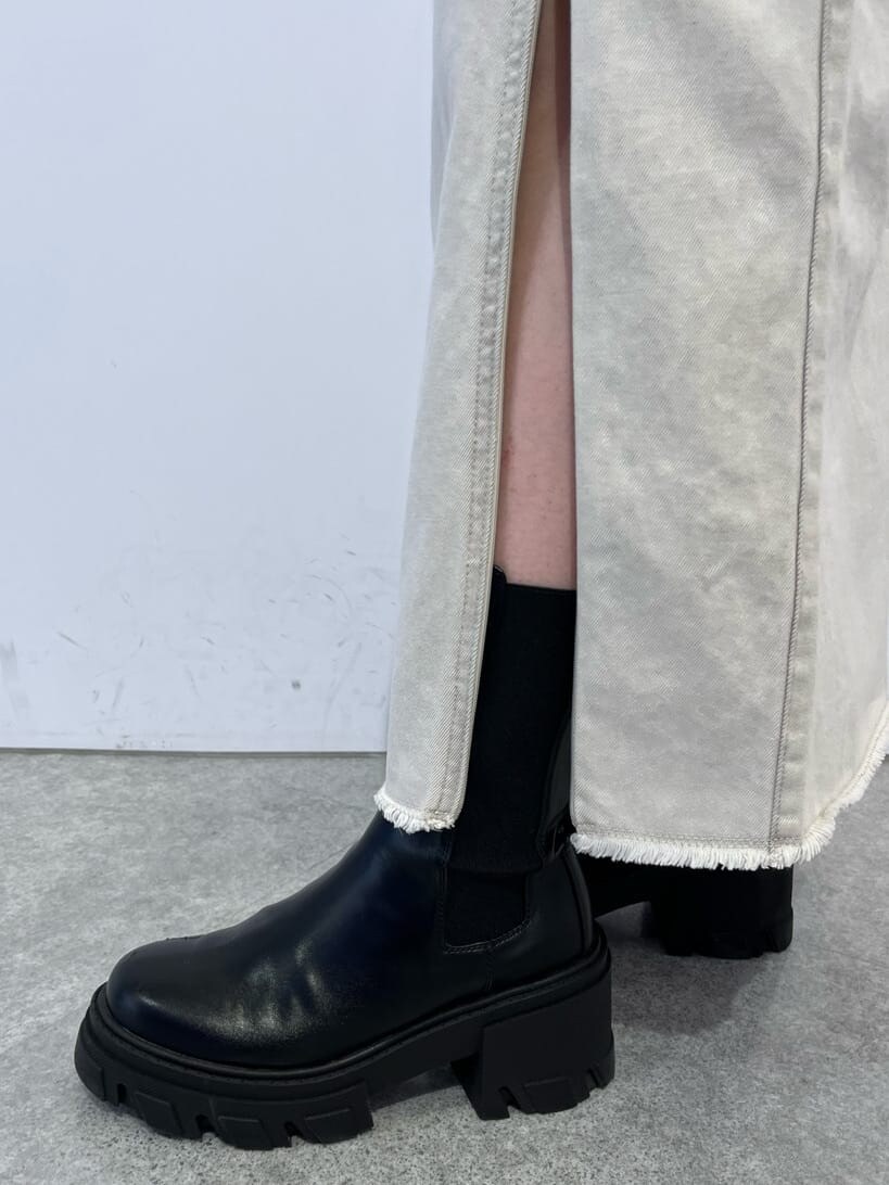 ホワイト系のデニムジャケット、ホワイト系のスカート、ブラック系のブーツを着用したレディースの夏コーディネートの8枚目の写真